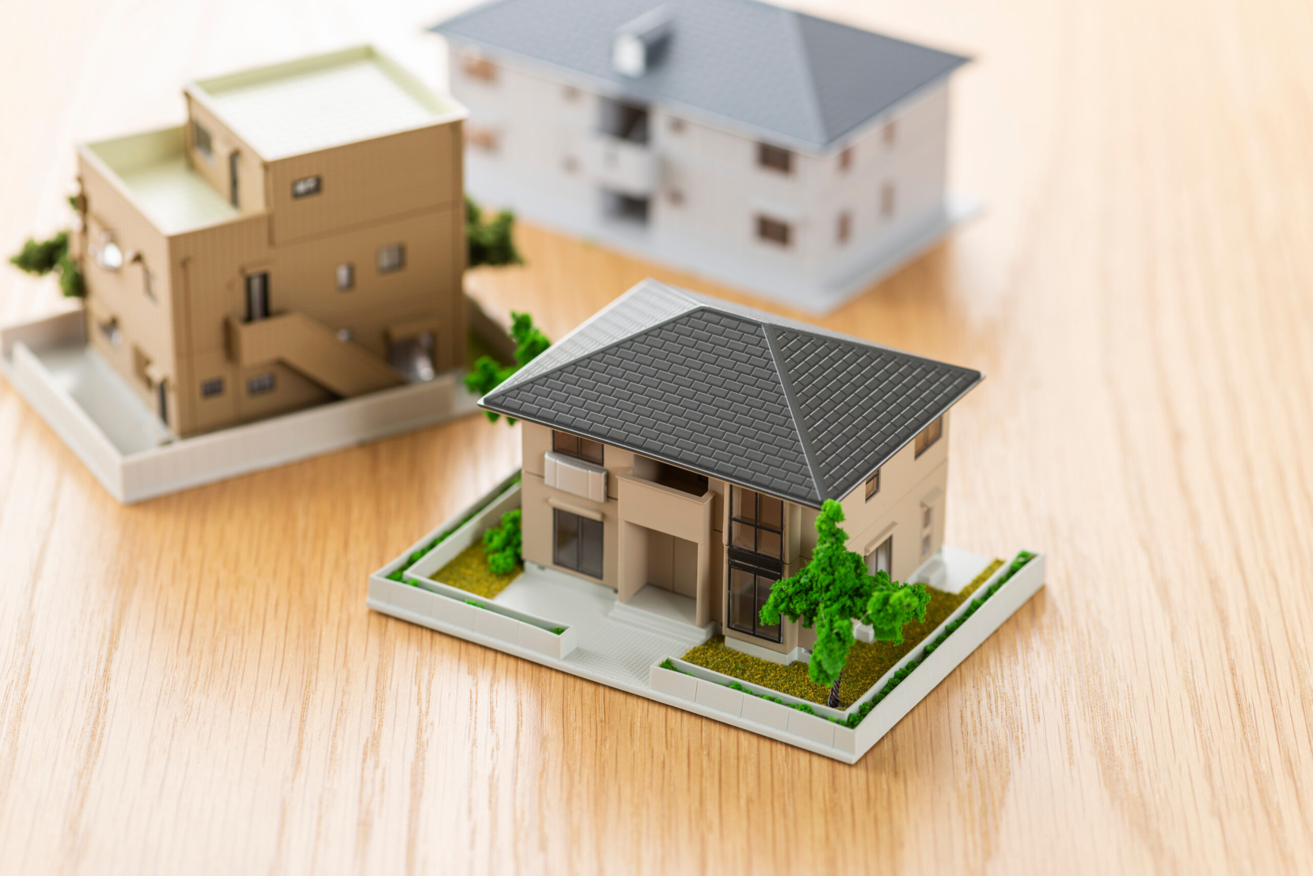 住宅模型を並べて資金計画やプランを検討するイメージ