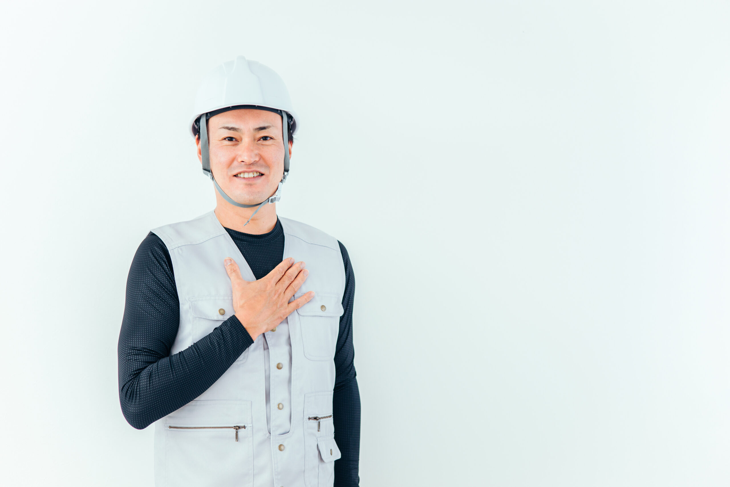 ヘルメットと作業ベスト姿で微笑む現場監督（デモ・イメージ）